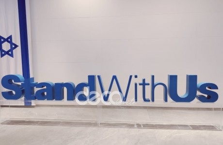 לוגו STAND WITH US בנוי מפיויסי על במת פרספקס שקופה