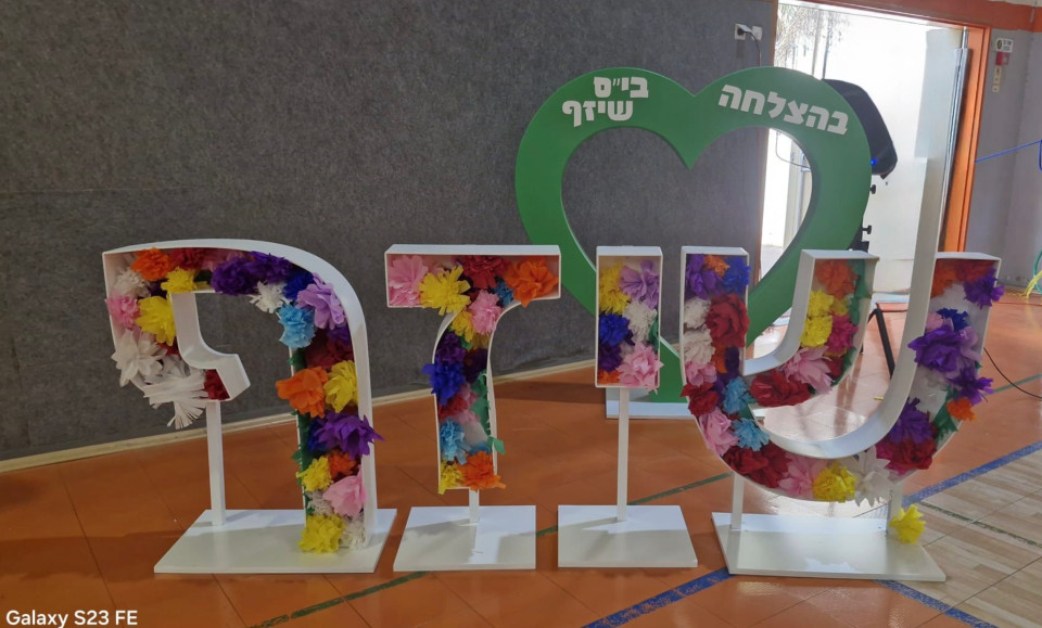 אותיות חלולות עם שם בית הספר למילוי ולב ירוק עם שם בית הספר